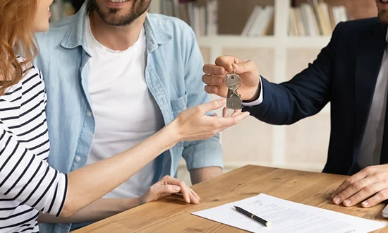 Couple receiving house keys after signing their mortgage agreement.